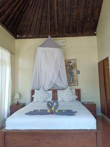 Ein Bett oder Betten in einem Zimmer der Unterkunft Putra'Lebah Amed Guest House