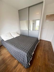 a bedroom with a bed in a room with wood floors at Studio confortable proche Paris in Châtillon