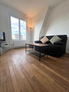 a living room with a couch and a coffee table at Studio confortable proche Paris in Châtillon