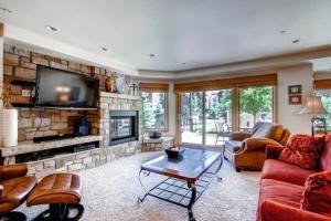 a living room with a fireplace and a tv at Ski In, Ski Out 2 Bedroom Vacation Rental In The Heart Of Lionshead Village With Heated Slope Side Pool And Hot Tub in Vail