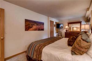 a hotel room with a large bed and a television at Ski In, Ski Out 2 Bedroom Vacation Rental In The Heart Of Lionshead Village With Heated Slope Side Pool And Hot Tub in Vail +18 photos