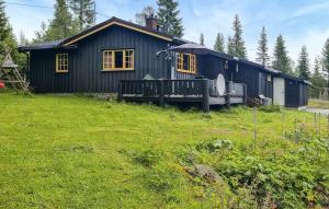 a black house with a yard in front of it at Månebu in Tunhovd