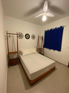 a bedroom with a bed and a ceiling fan at Vila Lorenzi & Apartamentos in Ubatuba