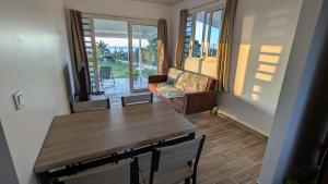 a living room with a table and a couch at Faaa Airport Lodge - Fare Mahana in Faaa