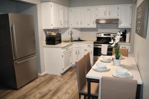 a kitchen with white cabinets and a table with chairs at Travelers Oasis in Eagle Pass