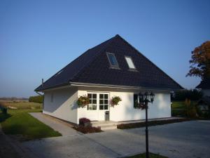 ein weißes Haus mit schwarzem Dach in der Unterkunft Ovelgönner Hof in Buxtehude