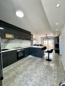 a kitchen with black cabinets and a black chair in it at Lujoso departamento en Playa el Angel in Pampatar