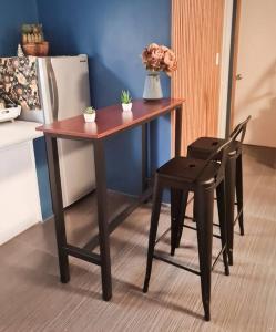a table and a chair next to a refrigerator at BacolodCrib in Bacolod +5 photos