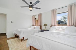 サンアントニオにあるCharming Home Near Sea World & Six Flags Sleeps 8のベッド2台と天井ファン付きの寝室