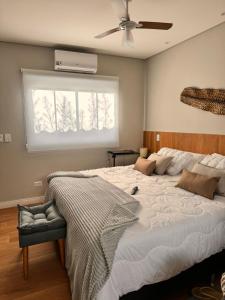 a bedroom with a large bed with a ceiling fan at La Estância Flats in Iguape