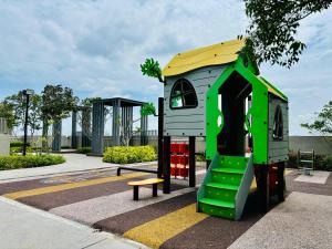 une aire de jeux avec une maison de jeu verte et jaune dans l'établissement Youth City Residence Nilai, à Nilai