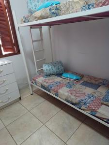 ein Schlafzimmer mit einem Etagenbett mit einem Stuhl darauf in der Unterkunft CASA ALOJAMENTO EMPRESAS ou GRUPO ÚNICO in Porto Alegre