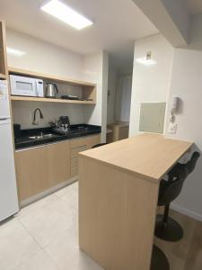 a kitchen with a counter and a sink and a refrigerator at Apartamento Inteiro Novo - 2 Quartos - REGIÃO CENTRAL FOZ in Foz do Iguaçu