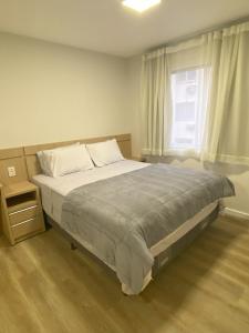 a bedroom with a bed and a window at Apartamento Inteiro Novo - 2 Quartos - REGIÃO CENTRAL FOZ in Foz do Iguaçu
