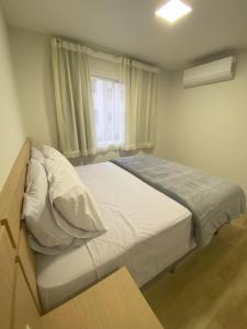 a bedroom with a bed with white sheets and a window at Apartamento Inteiro Novo - 2 Quartos - REGIÃO CENTRAL FOZ in Foz do Iguaçu +23 photos