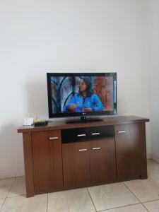 einen Flachbild-TV auf einem hölzernen Entertainment-Center in der Unterkunft CASA ALOJAMENTO EMPRESAS ou GRUPO ÚNICO in Porto Alegre