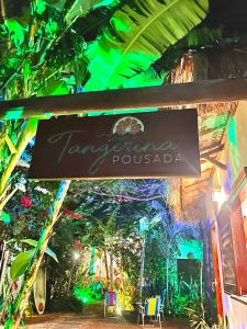a sign in front of a restaurant with lights at Pousada Tangerina in Icaraí