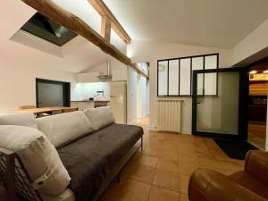 a living room with a couch and a kitchen at La Bergerie du figuier in Céret