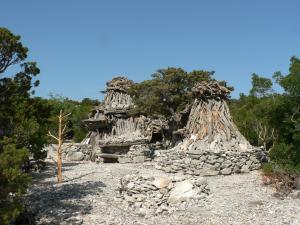 a small stone building with trees in the background at Hotel Bia Maore in Baunei