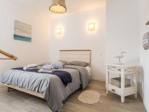 a bedroom with a bed and a white table at Gîte chaleureux à Assérac, proche mer, jardin privé, wifi - FR-1-306-1285 in Assérac