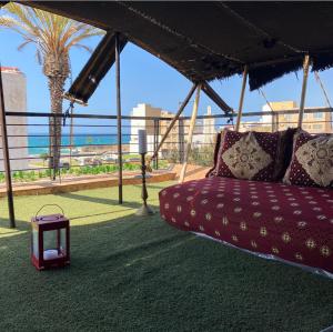 a couch under a tent with a table and a palm tree at Villa Dar Lghzal Private Villa with Garden, Rooftop & Authentic Dining in Rabat in Rabat