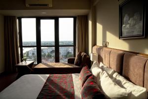 a hotel room with two beds and a large window at Asia Hotel Hue in Hue