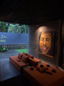 a living room with a couch and a painting on the wall at Saffron Robes Living in Hikkaduwa