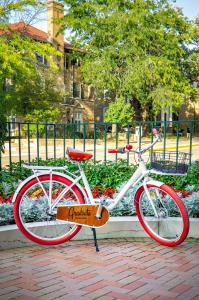 una bicicleta roja y blanca estacionada en una acera de ladrillo en Graduate Madison, en Madison