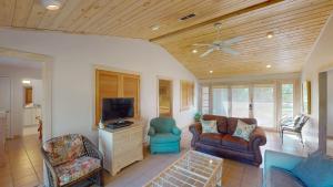a living room with a couch and a tv at ALWAYS TURTLE CRAWL home in Jekyll Island