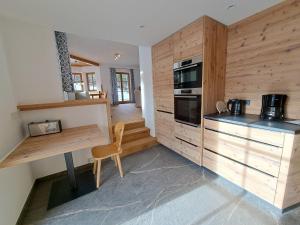 a kitchen with wooden cabinets and a table with a stove at Ferienhaus Hirschwiesn -565- in Krün