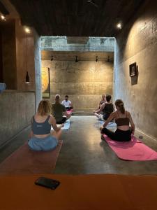 a group of people sitting in a room doing yoga at Saffron Robes Living in Hikkaduwa