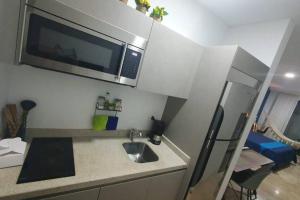 a kitchen with a sink and a microwave at Estudio de playa Monpal in Playa del Carmen