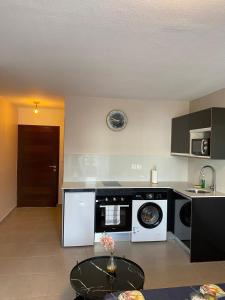 a kitchen with a washer and dryer in it at Pacifique Suite in Cayenne