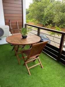 a table and chairs on a balcony with green grass at Pacifique Suite in Cayenne