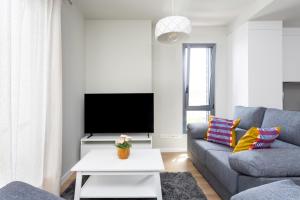 a living room with a couch and a tv at OkStay - Apto de lujo con piscina, a 300m del mar in Arico