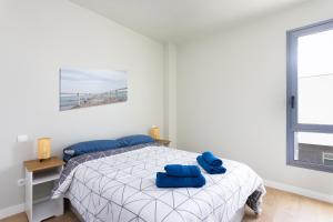 a bedroom with a bed with blue pillows on it at OkStay - Apto de lujo con piscina, a 300m del mar in Arico +24 photos