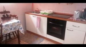 a kitchen with a sink and a stove at Gardenia House in Marina di Grosseto +7 photos