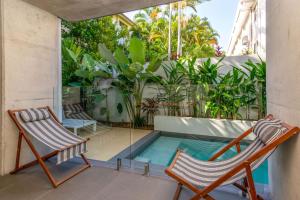 a balcony with two chairs and a swimming pool at Aria Villa 2 Port Douglas in Port Douglas