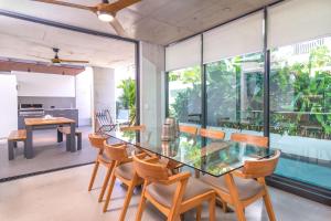 a dining room with a glass table and chairs at Aria Villa 2 Port Douglas in Port Douglas