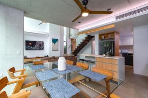 a dining room and kitchen with a glass table and chairs at Aria Villa 2 Port Douglas in Port Douglas