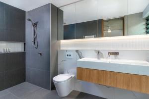 a bathroom with a toilet and a sink and a mirror at Aria Villa 2 Port Douglas in Port Douglas +21 photos