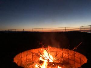 a fire pit with a fence in the background at Cliffside Cottage in Oak Harbor