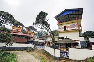 a tall building with a fence in front of it at Hotel O Valley View Residency in Vagamon