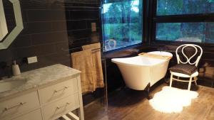 La salle de bains est pourvue d'une baignoire, d'un lavabo et d'une chaise. dans l'établissement Stanthorpe Heritage Estate, à Dalveen 77 autres photos