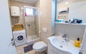 a bathroom with a sink and a toilet and a shower at Apartman Mary in Široki Brijeg