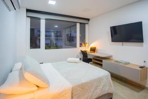a bedroom with a bed and a flat screen tv at 102 Norte cali - The view in Cali