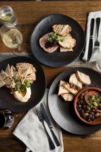 a wooden table with plates of food and glasses of wine at Yarra Valley Lodge in Wonga Park