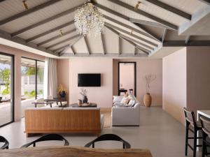 a living room with a couch and a chandelier at Villa Haven Resort Maldives - 50 Percentage Off Seaplane for 4 Nights and Above in Maamigili