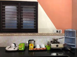 a kitchen counter with a microwave and some food at Nature Inn Cottages in Gokarna