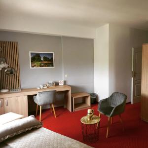 a bedroom with a bed and a desk and two chairs at Hotel Villa Valpovo in Valpovo